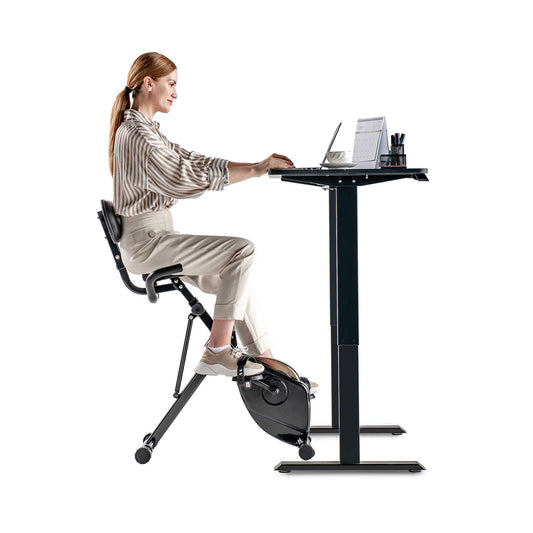 Egofit desk bike with model working at adjustable standing desk